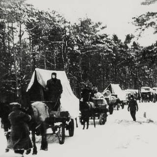 Während des Zweiten Weltkriegs flüchten Menschen im Schnee mit Kutschen. 