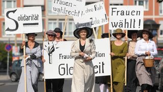 Mit Plakaten und in historischen Gewändern gehen Frauen der Arbeitsgemeinschaft Sozialdemokratischer Frauen (ASF) am Montag (17.08.2009) durch Dresden. Die Frauen wollen mit der Aktion die Wahlrechtsdemonstrationen der Suffragetten vor 100 Jahren nachstellen und die Bürgerinnen bei den bevorstehenden Wahlen zur Teilnahme auffordern. Foto: Ralf Hirschberger dpalsn +++(c) dpa - Bildfunk+++