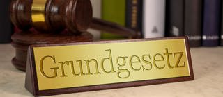 Grundgesetzschild und ein Hammer